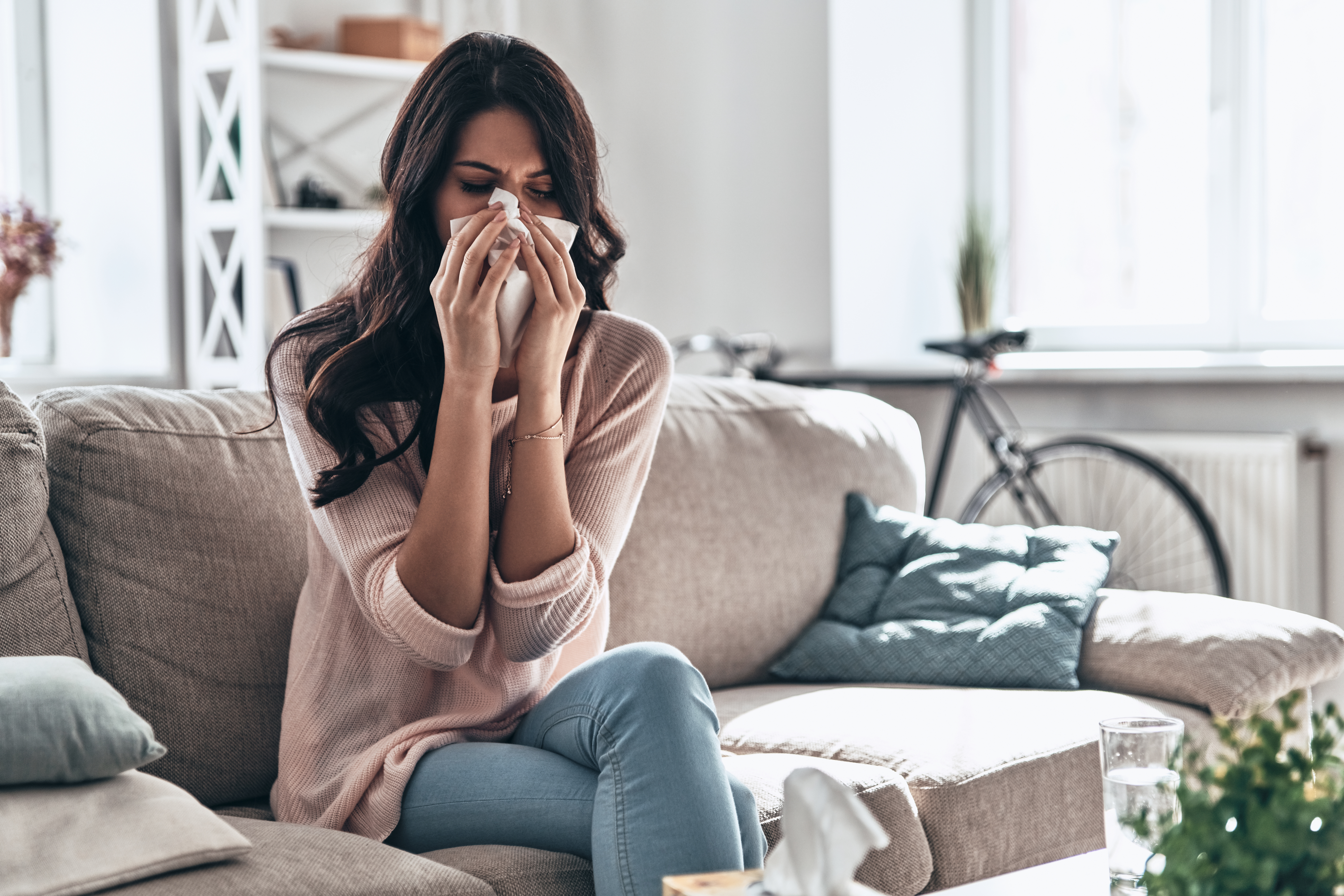 Cold and flu. Sick young woman blowing the nose using tissue pap